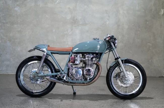 1974 Honda CB550 cafe racer built by Purpose Built Moto featuring vintage grey paint, custom tail section, and Mikuni carb setup