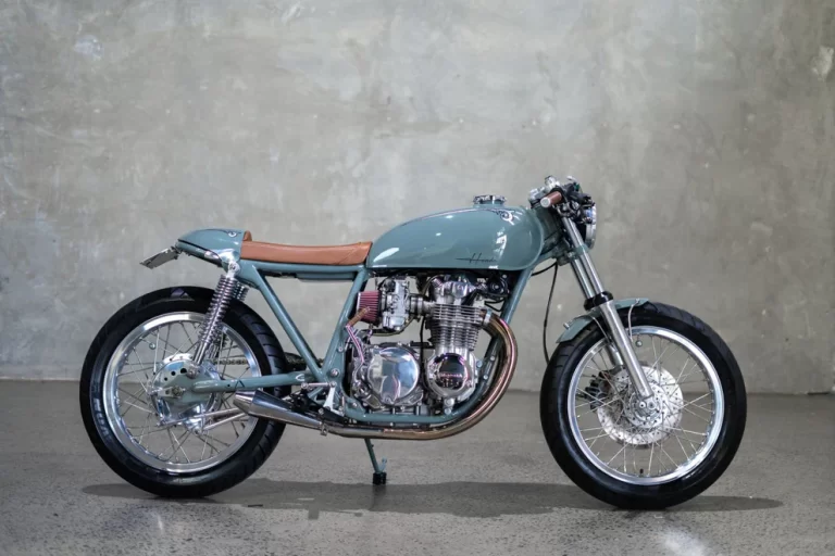 1974 Honda CB550 cafe racer built by Purpose Built Moto featuring vintage grey paint, custom tail section, and Mikuni carb setup