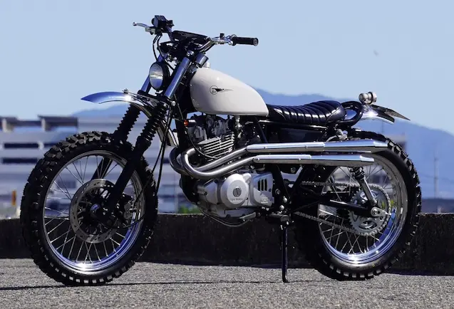 Heiwa Motorcycle custom Suzuki Grass Tracker 250 scrambler with white tank and knobby tires side profile