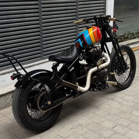 Rear three quarter view of Royal Enfield Bullet 500 chopper by VP Designs Custom Paintshop with retro rainbow fuel tank