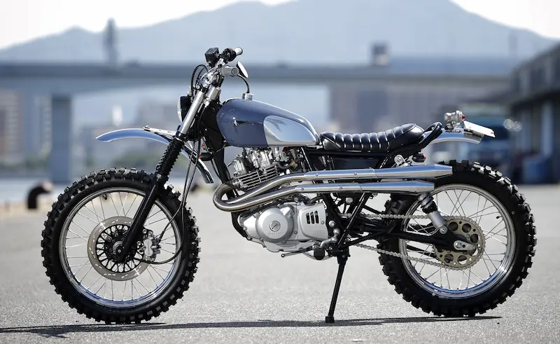 Heiwa Motorcycle custom Suzuki Grass Tracker 250 scrambler with grey tank and dual exhaust side view